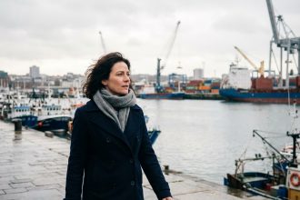 Femme en manteau marin regardant le port de Brest